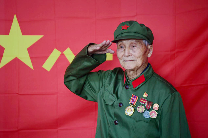 楊秀友在軍旗前敬禮。（吉林省退役軍人事務廳供圖）