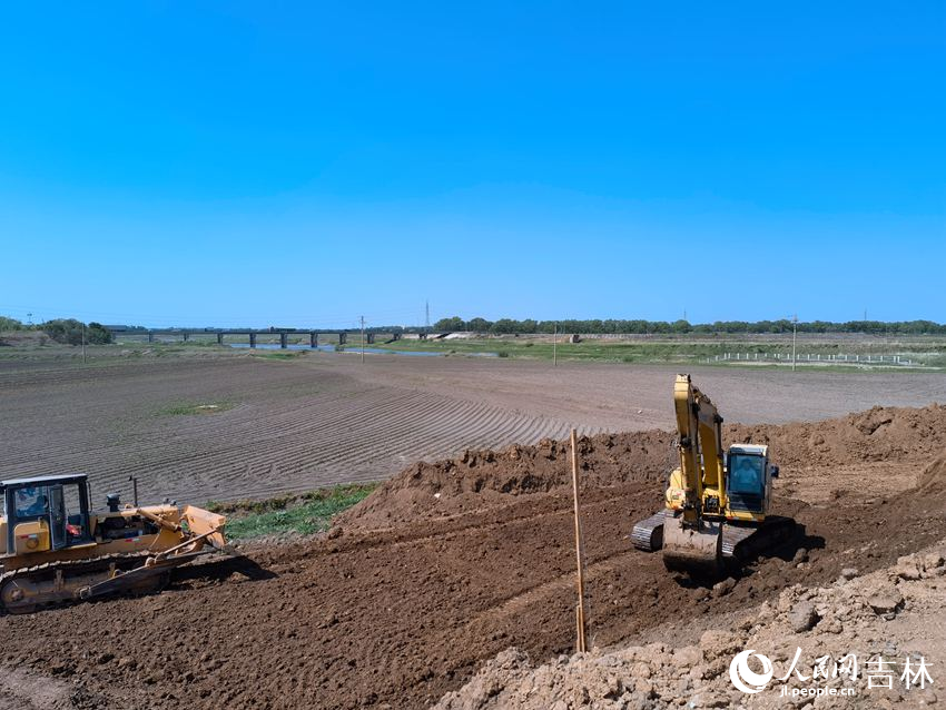 兩臺工程車“加培”堤防忙不停。人民網記者 馬俊華攝