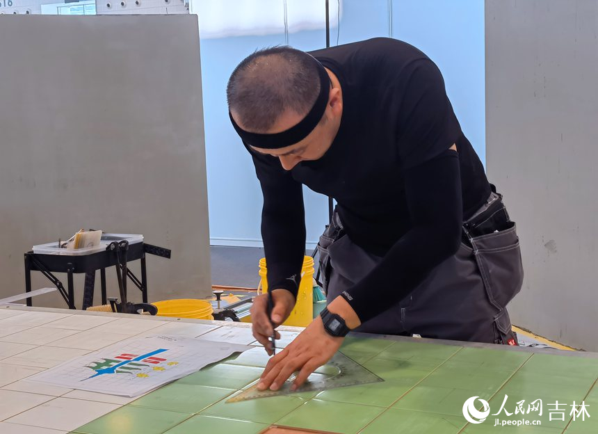 室內裝飾設計賽項選手寇文博正在瓷磚上劃線。人民網記者 馬俊華攝