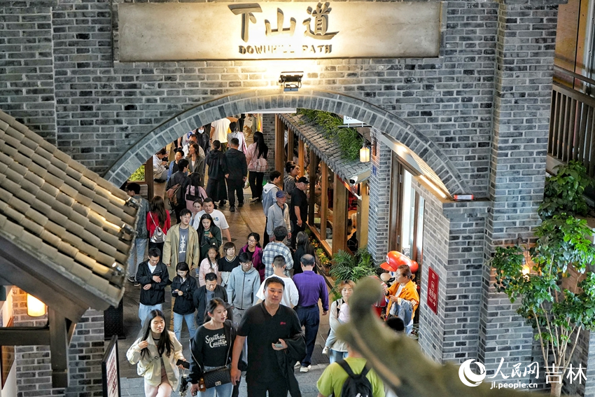 夜色降臨，游客在位于長春市的“這有山”文旅小鎮逛街購物。人民網記者 李洋攝