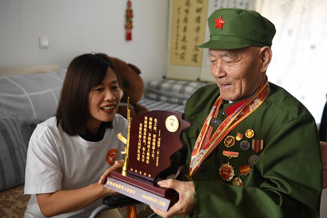 吉林省退役軍人事務廳工作人員向老兵徐洪英贈送榮譽紀念牌。