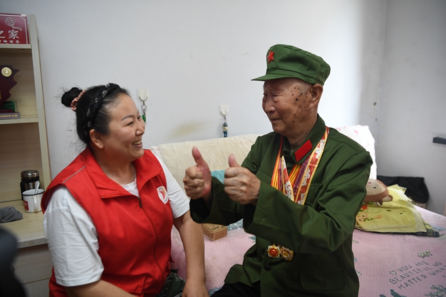 老兵朱萬金向關愛老兵志愿者表達感謝。