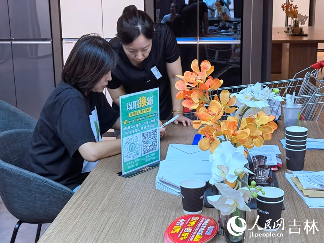 商場銷售人員指導消費者使用以舊換新小程序。人民網記者 馬俊華攝