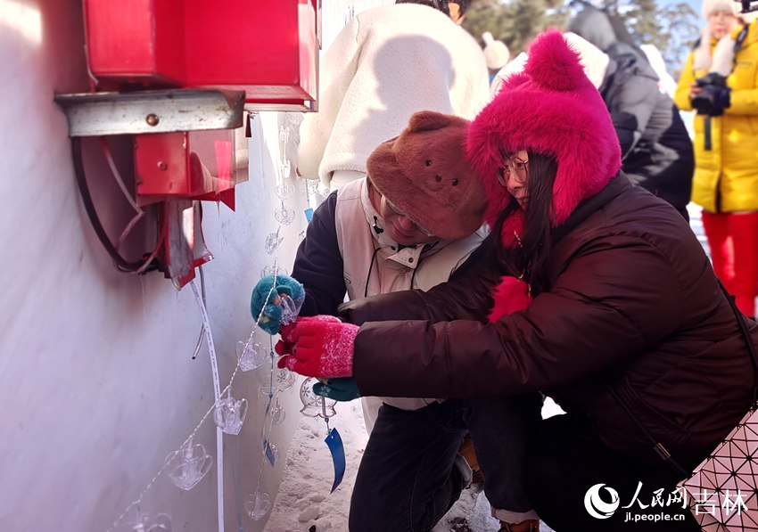 一對戀人雪花風鈴掛于美人松寄情壁上。人民網記者 關思聰攝