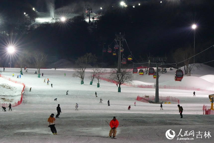 新雪季“開板”以來，吉林省各大滑雪場紛紛推出夜滑模式，通過延長營業時間、增加雪道數量、提升雪道長度等豐富夜滑者體驗。圖為滑雪愛好者在吉林松花湖滑雪度假區夜間暢滑。人民網記者 李洋攝