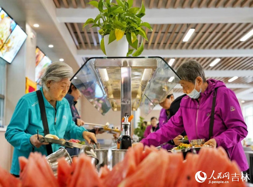 長春市飛躍街道三佳社區敬老餐廳內，市民正在選取午餐。人民網記者李洋攝