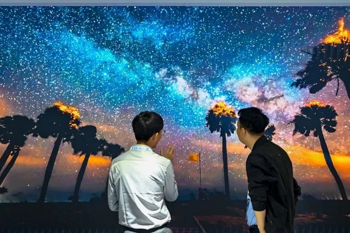 長春光博會希達電子展區，一位工作人員正在給一位觀眾講解。（長春新區供圖）