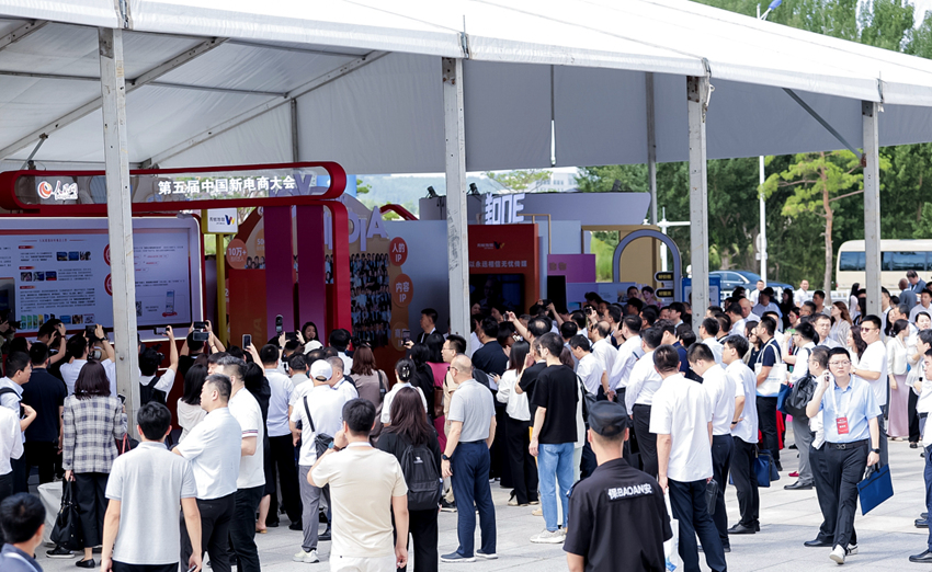 開幕式前，與會嘉賓在人民優選、抖音等展位前，與工作人員交流新電商發展（主辦方供圖）