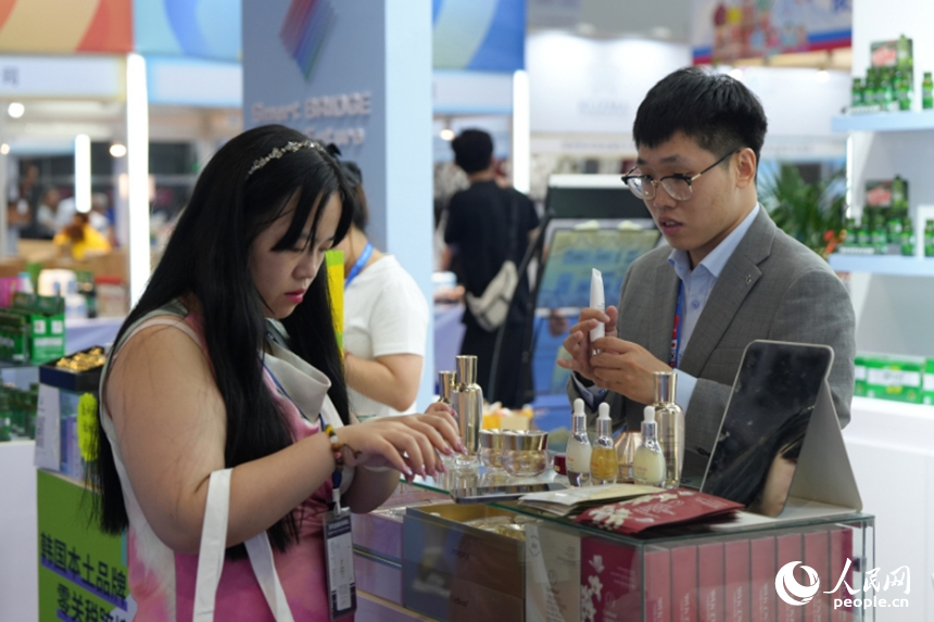 一名游客在第十五屆中國—東北亞博覽會上試用韓國化妝品。人民網記者 李洋攝