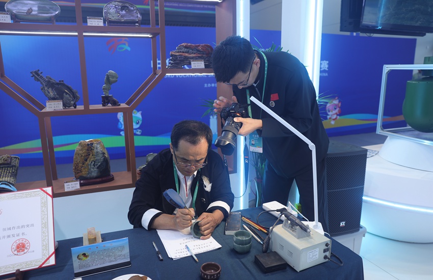 吉林省工藝美術大師、省級非遺傳承人竇茂忠認真雕刻著手中的松花石。不一會兒工夫，一個個精美的字組成極具韻味的詞句，躍然“石”上。楊宜修攝
