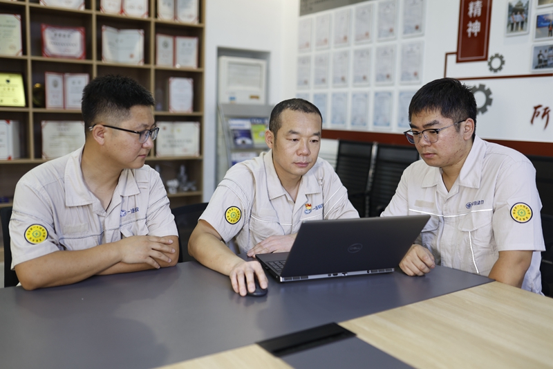 聶新宇（中）在工作室內發揮傳幫帶作用，帶領技術人員共同學習技術