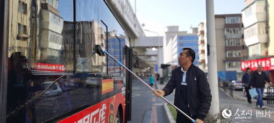 10月4日一早，吉林省長春市271路車站，司機何師傅發車前為公交車做好清潔工作，確保乘客舒心出行。人民網記者 王帝元攝