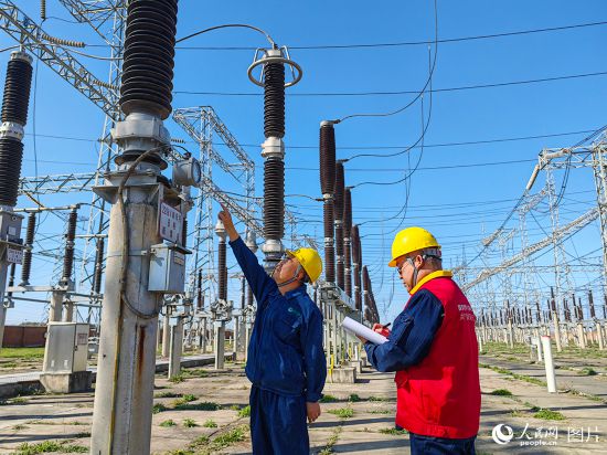 10月1日上午，國網長春供電公司變電運維中心在德惠220千伏變電站查看220千伏南母線避雷器壓力示數，保證國慶期間線路安全運行。人民網 李成偉攝