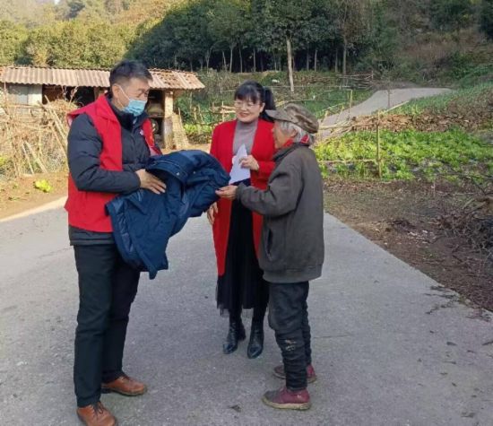 湖北省十堰市應急管理局工作人員將冬衣送到村民手中。受訪者供圖