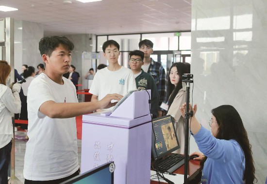 2025年高考即將拉開帷幕。6月6日，長春市的考生們提前來到考點，熟悉考場環境，從容備考。圖為在長春市團山學?？键c，考生正在通過人臉識別核驗身份。（記者 李姣月 攝）